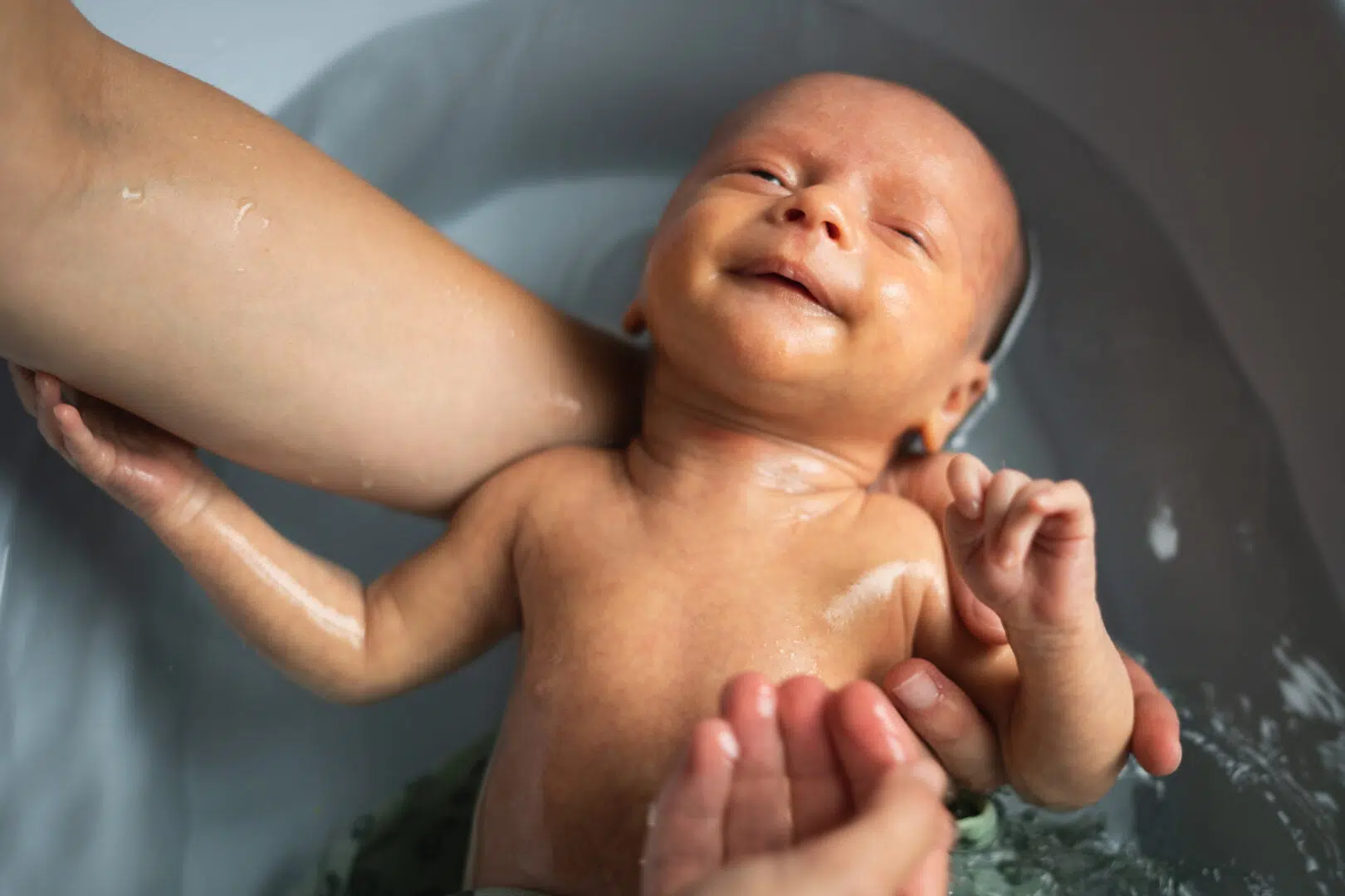 photo d'un nouveau né souriant dans un bain