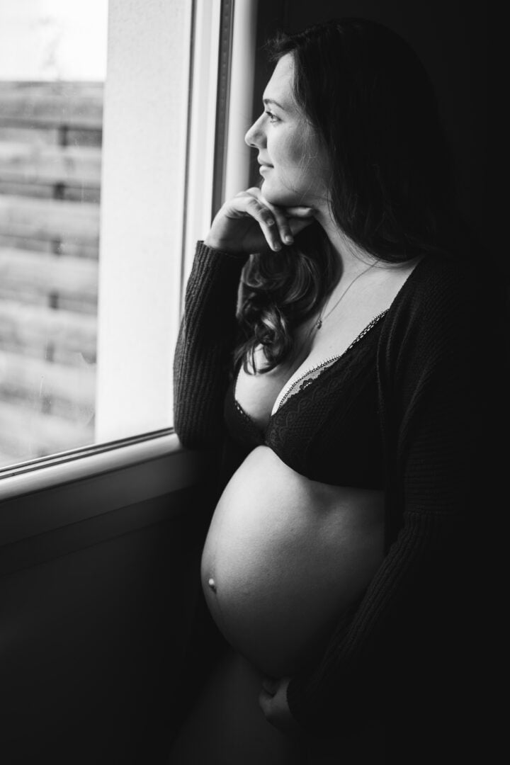 photo d'une femme enceinte regardant par une fenêtre à rennes