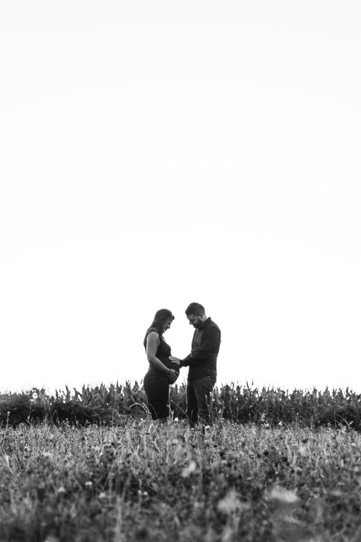 séance photo betton grossesse couple dans un champs