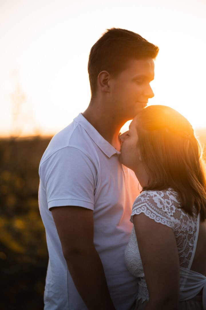 Gros plan complice d'un couple sous la lumière dorée pour séance engagement
